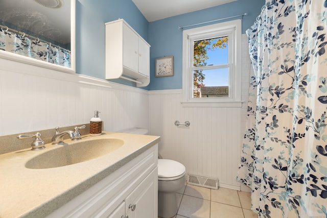 bathroom featuring walk in shower, vanity, toilet, and tile patterned floors