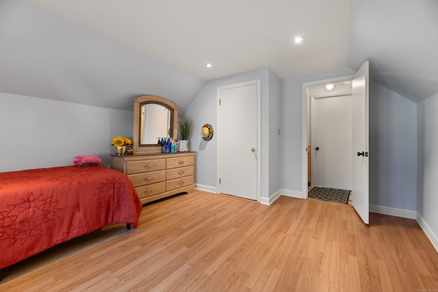 bedroom featuring light hardwood / wood-style floors and vaulted ceiling