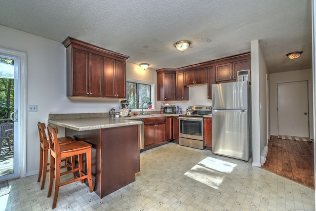 kitchen featuring stainless steel appliances, light wood-type flooring, sink, and a wealth of natural light