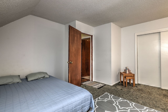 carpeted bedroom featuring a closet, vaulted ceiling, and a textured ceiling