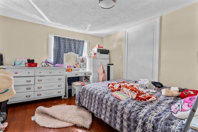 bedroom with a textured ceiling and dark wood-type flooring