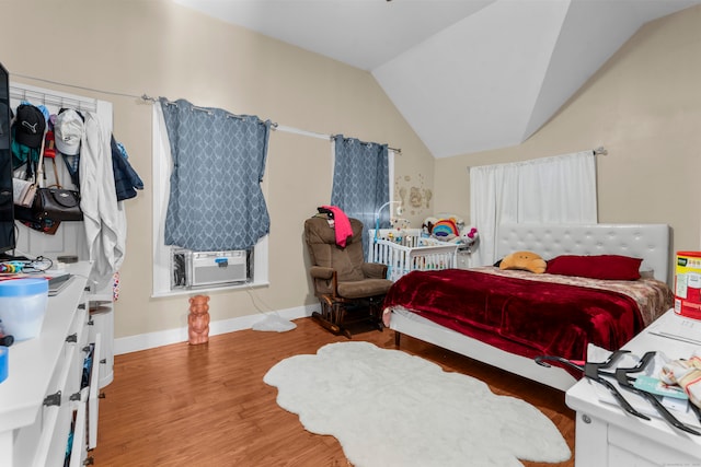 bedroom with hardwood / wood-style flooring, cooling unit, and lofted ceiling