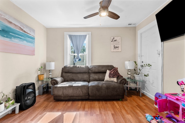 living room with ceiling fan and light hardwood / wood-style flooring