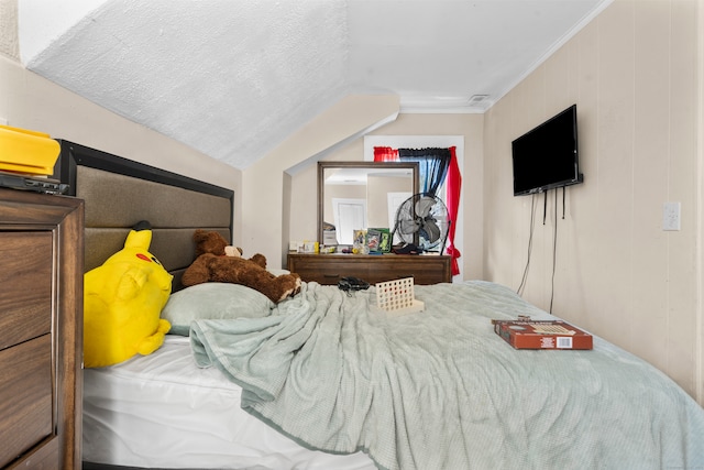 bedroom featuring ornamental molding, a textured ceiling, and vaulted ceiling