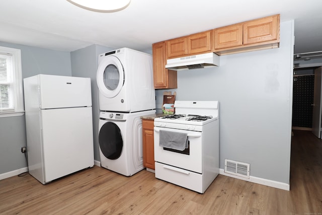 kitchen featuring light hardwood / wood-style floors, stacked washer and clothes dryer, and white appliances