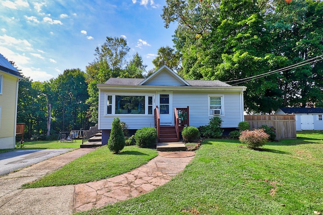 view of front of home featuring cooling unit and a front yard