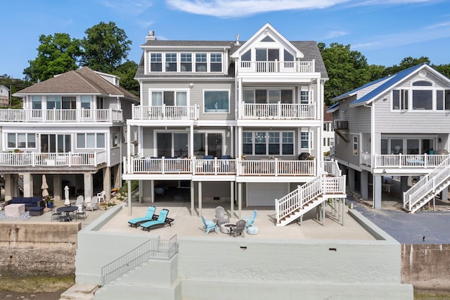 back of property featuring a chimney, a patio area, and stairway