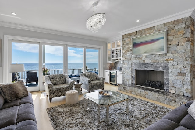 living room with a water view, light wood finished floors, wine cooler, and ornamental molding