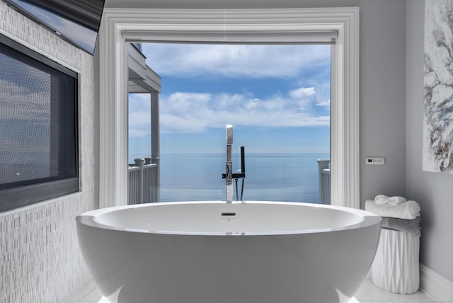 bathroom with a freestanding bath and a water view