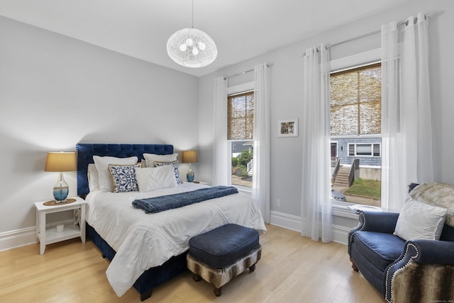 bedroom featuring light wood finished floors and baseboards