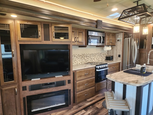 kitchen featuring a kitchen island, dark hardwood / wood-style floors, tasteful backsplash, hanging light fixtures, and appliances with stainless steel finishes