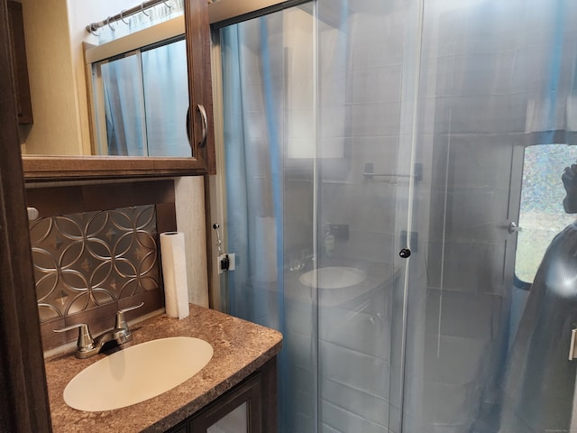 bathroom featuring a healthy amount of sunlight, vanity, and a shower with shower door