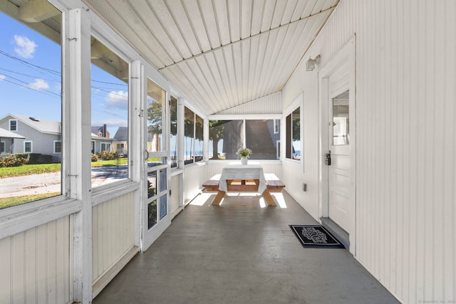 unfurnished sunroom featuring vaulted ceiling and a wealth of natural light