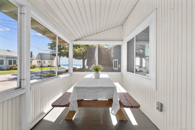 sunroom with a water view, a wealth of natural light, vaulted ceiling, and wood ceiling