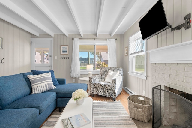 living room featuring a brick fireplace, hardwood / wood-style floors, beam ceiling, wood walls, and baseboard heating