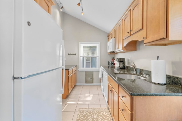 kitchen with white appliances, sink, dark stone counters, vaulted ceiling, and light tile patterned floors