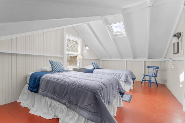 bedroom featuring wood walls, vaulted ceiling with skylight, and hardwood / wood-style floors