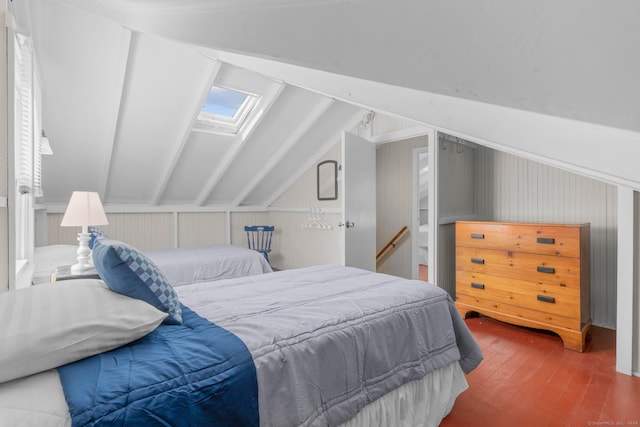 bedroom with hardwood / wood-style flooring and vaulted ceiling with skylight