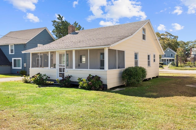 bungalow-style house featuring a sunroom and a front yard