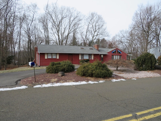 ranch-style home with driveway and a chimney