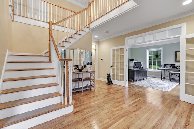 entrance foyer featuring hardwood / wood-style flooring, crown molding, and french doors