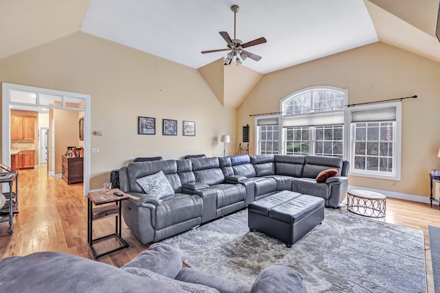 living room featuring light hardwood / wood-style floors, ceiling fan, and lofted ceiling