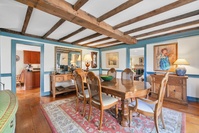 dining room featuring beam ceiling and hardwood / wood-style flooring