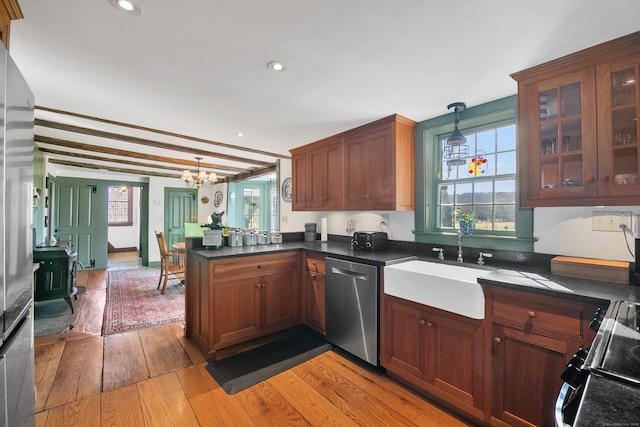 kitchen featuring hanging light fixtures, light hardwood / wood-style floors, range, kitchen peninsula, and dishwasher