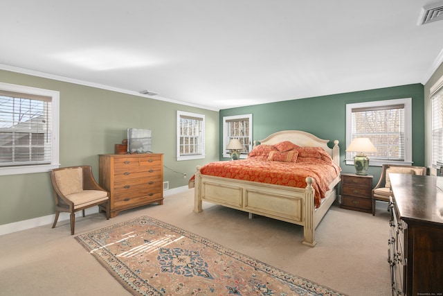 bedroom with ornamental molding and light colored carpet