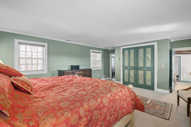 bedroom featuring ensuite bath, ornamental molding, and carpet