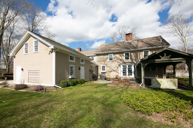 back of house with a lawn and a patio area