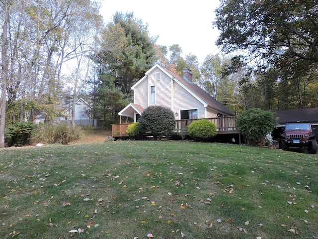 view of side of home with a lawn and a wooden deck