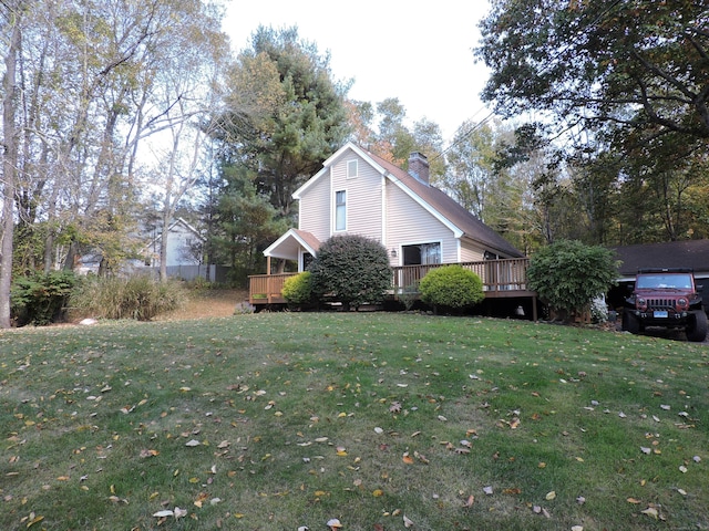 view of side of home featuring a deck and a lawn