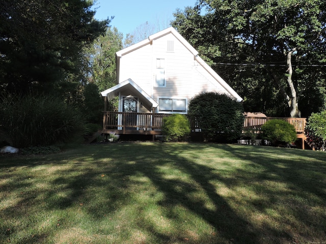 exterior space featuring a wooden deck and a lawn