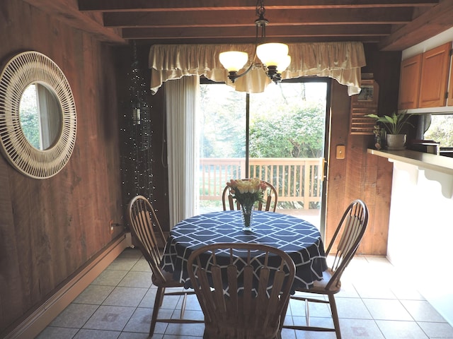 dining space with light tile patterned flooring, plenty of natural light, wooden walls, and beam ceiling