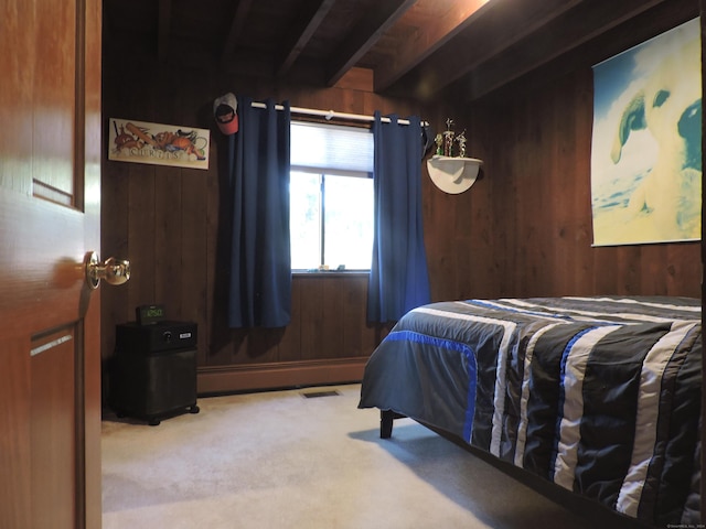 carpeted bedroom featuring baseboard heating, wood walls, and beamed ceiling