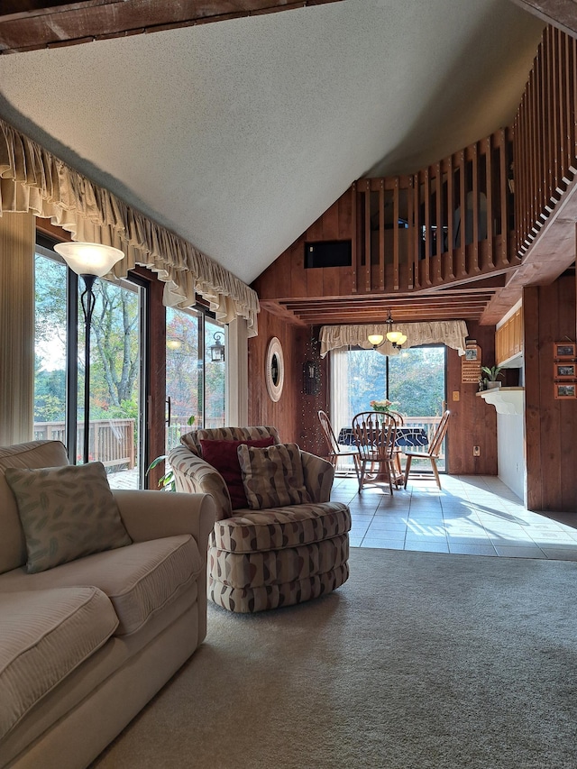 living room featuring vaulted ceiling, light colored carpet, wooden walls, and a textured ceiling