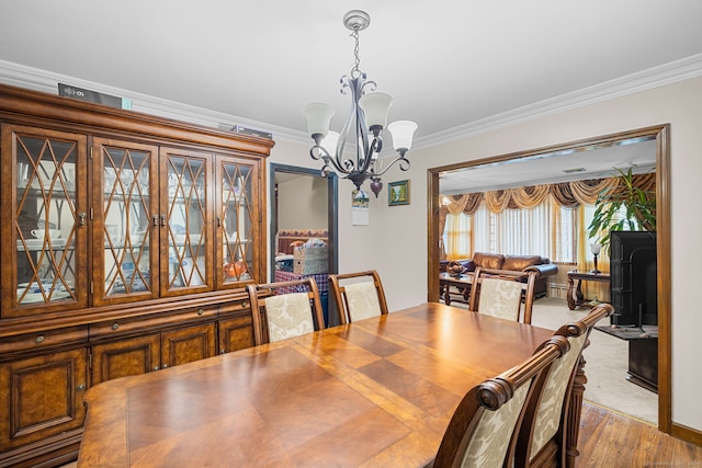 dining room featuring a notable chandelier, crown molding, and hardwood / wood-style flooring