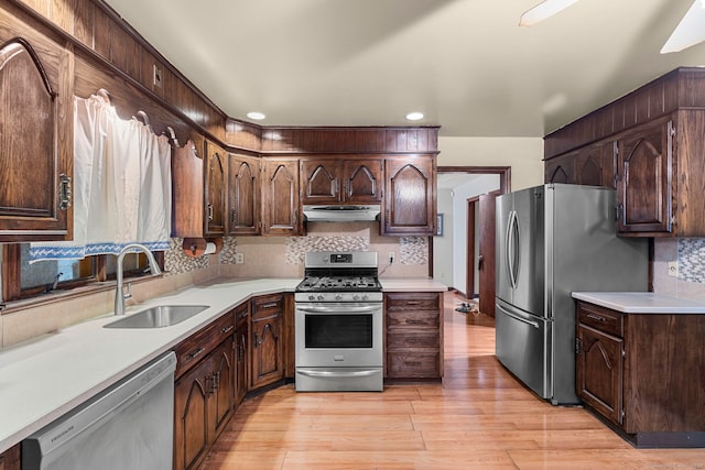 kitchen featuring decorative backsplash, stainless steel appliances, sink, light hardwood / wood-style flooring, and dark brown cabinets