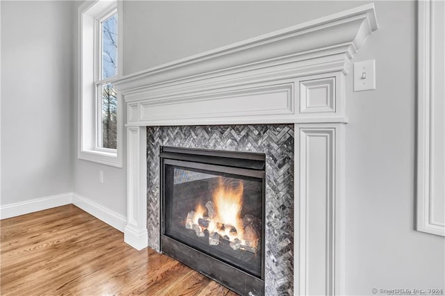 details featuring hardwood / wood-style flooring and a tiled fireplace