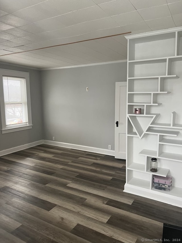 spare room with ornamental molding and dark hardwood / wood-style flooring