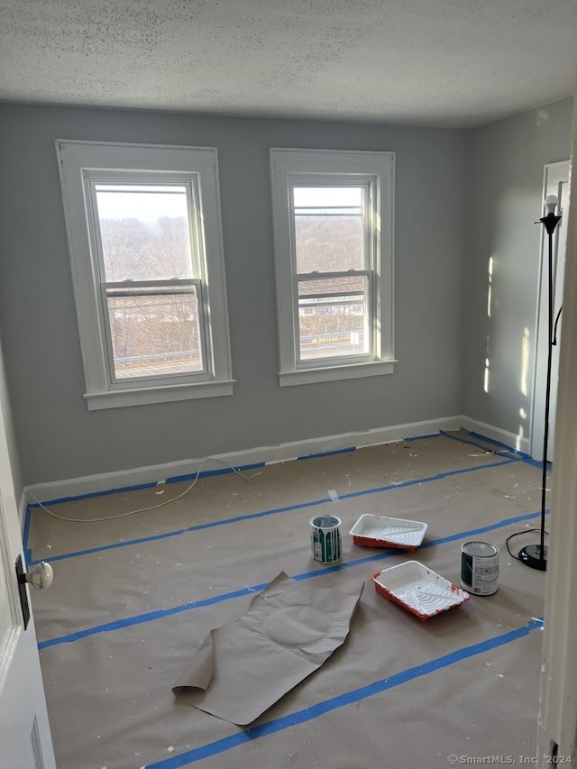 empty room with a textured ceiling and a wealth of natural light