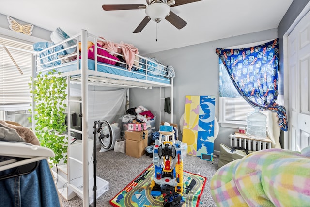 carpeted bedroom featuring ceiling fan, cooling unit, and radiator heating unit