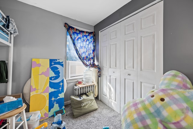 bedroom with radiator, carpet, and a closet