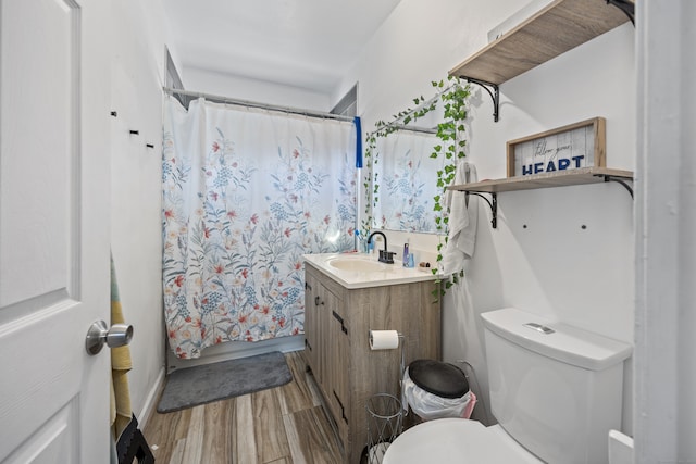 bathroom with a shower with shower curtain, wood-type flooring, vanity, and toilet