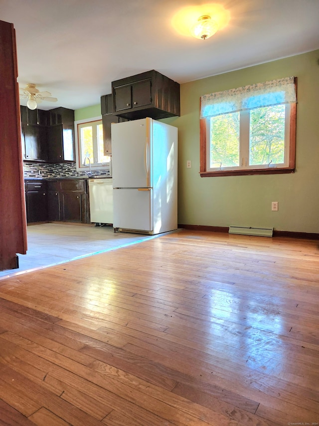 kitchen with ceiling fan, white appliances, a baseboard radiator, light hardwood / wood-style floors, and decorative backsplash