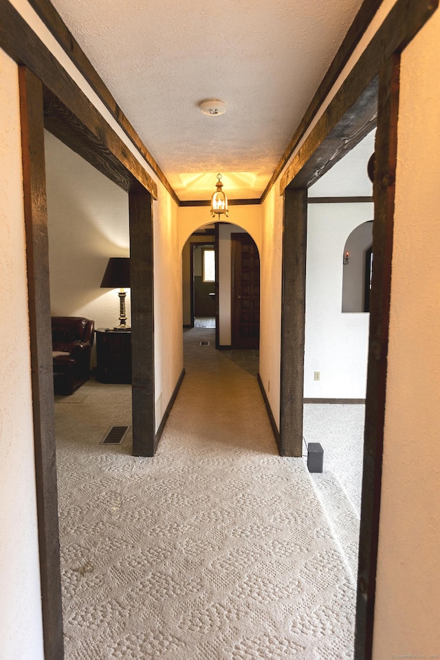 corridor featuring carpet floors and a textured ceiling