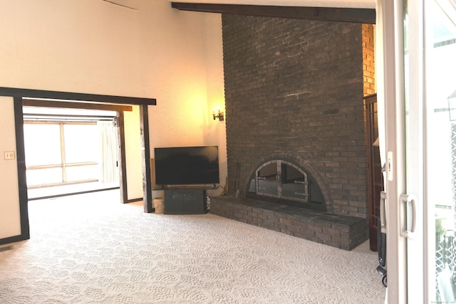 unfurnished living room featuring light carpet, beam ceiling, and a fireplace