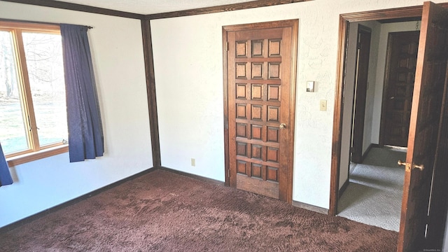 unfurnished room featuring dark carpet and crown molding