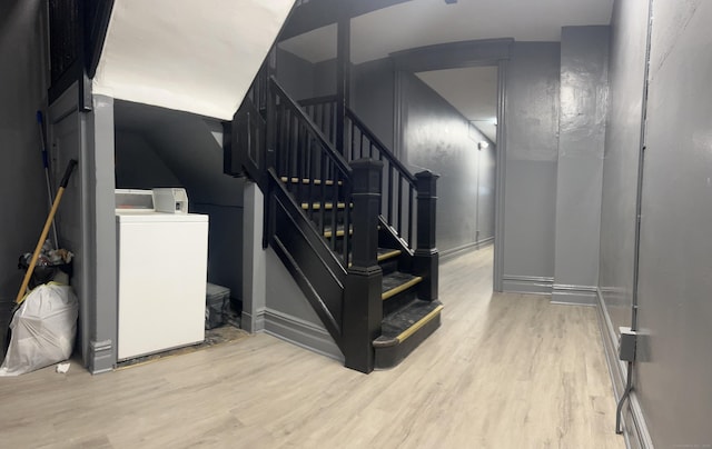 staircase featuring washer / clothes dryer and hardwood / wood-style floors